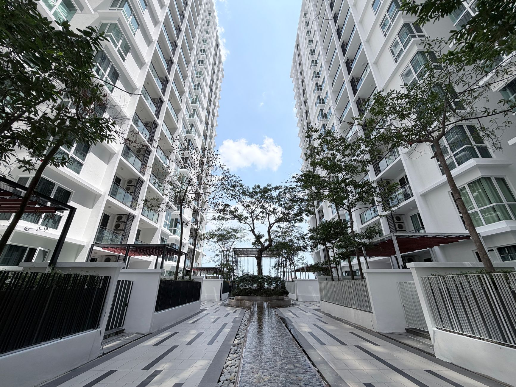 Exterior modern Apartemen The H Residence dengan pencakar langit, taman hijau, dan fasilitas lengkap di pusat kota